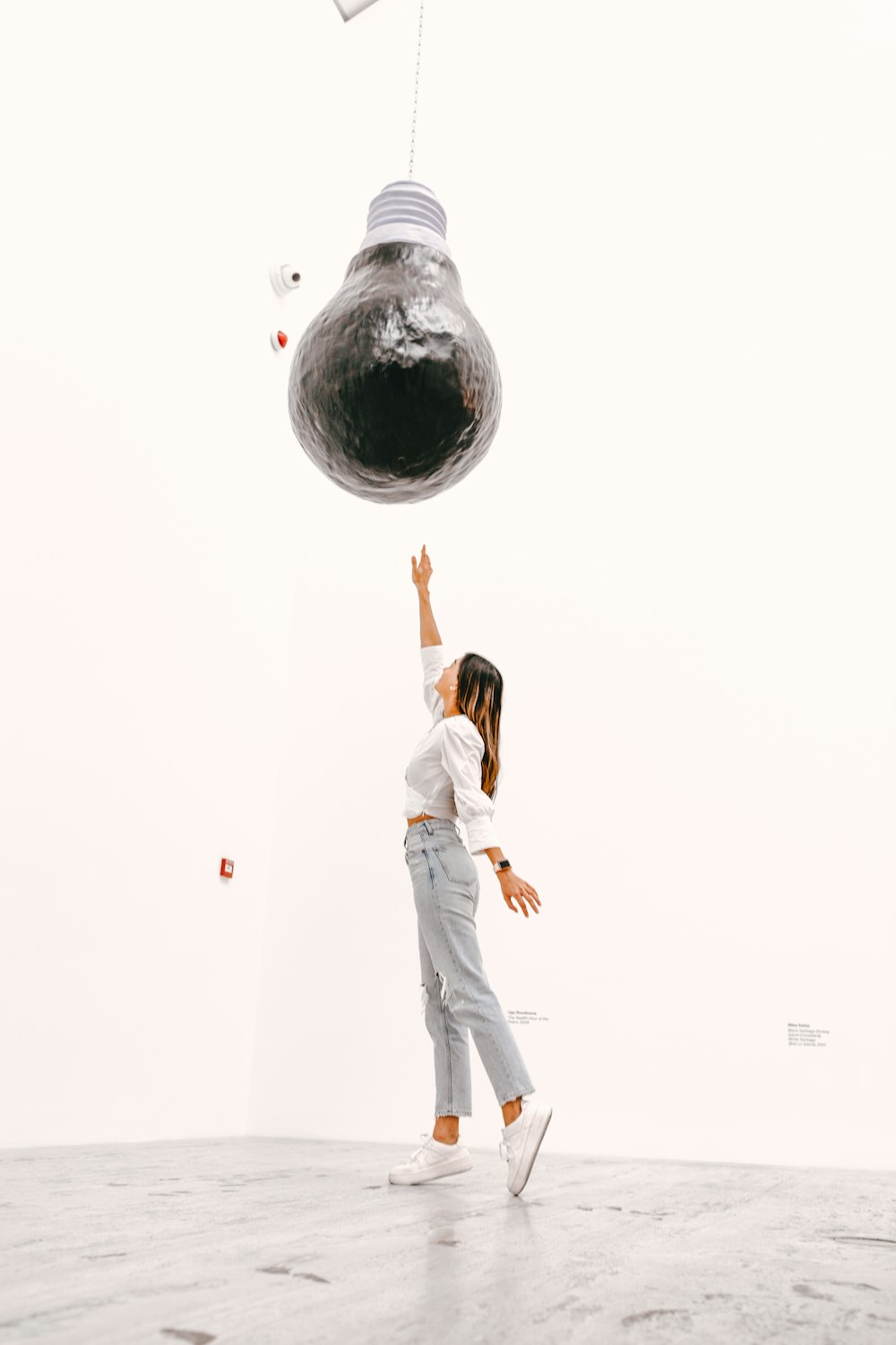 Frau in weißem ärmellosem Kleid auf Globus stehend