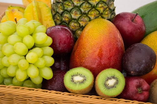 pomme rouge à côté d'une pomme verte et d'un fruit jaune sur un panier tressé marron