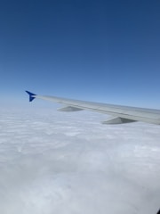 Aerial view of a modern airplane flying above clouds.