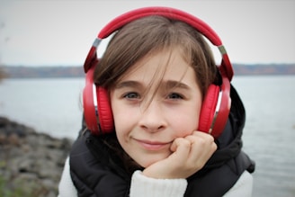 girl in black jacket wearing red headphones