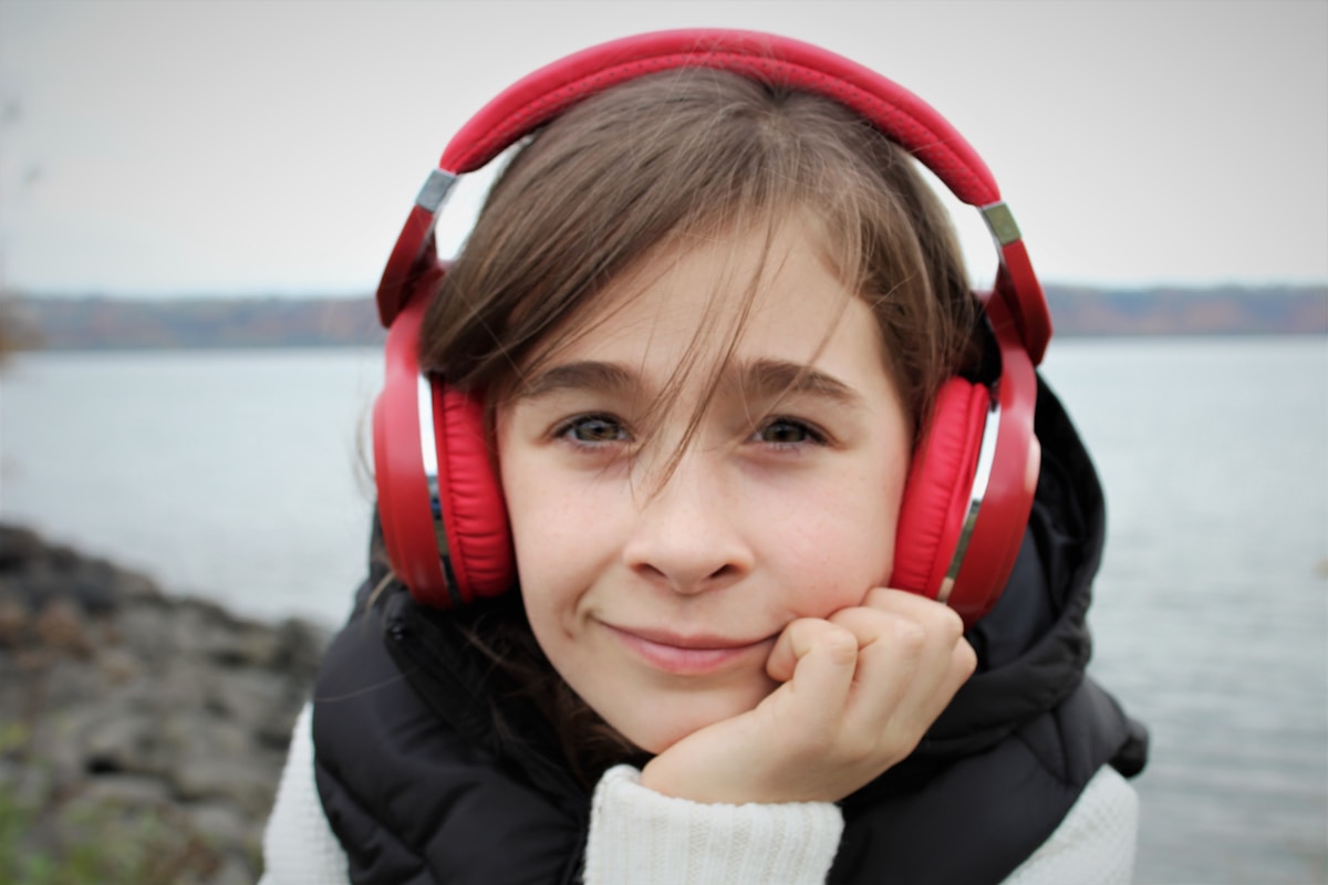 Girl in black jacket wearing red headphones
