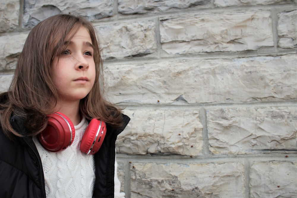 girl in black jacket wearing red headphones