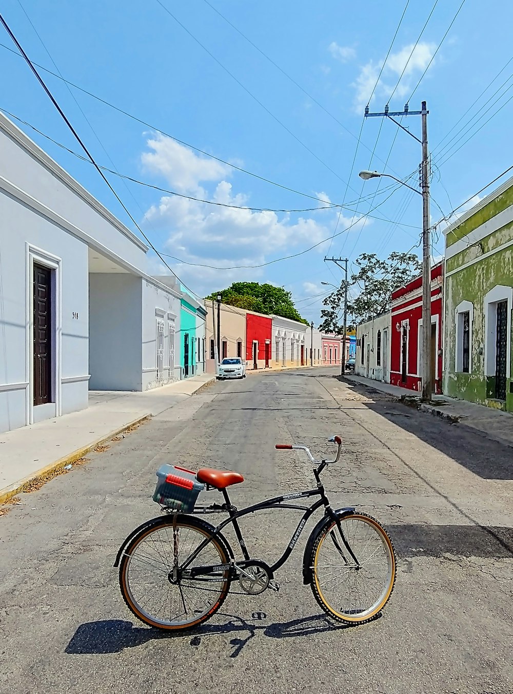 black city bike parked beside red and white concrete building during daytime
