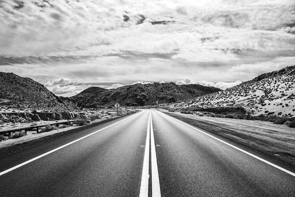 grayscale photo of road near mountain