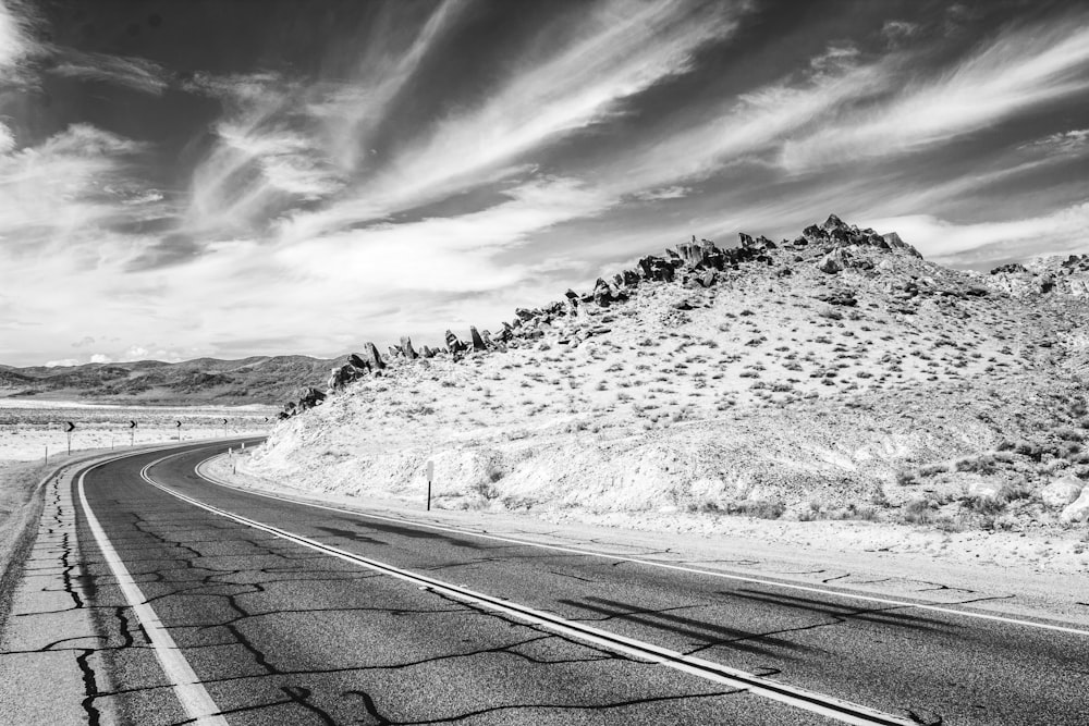 grayscale photo of road near mountain