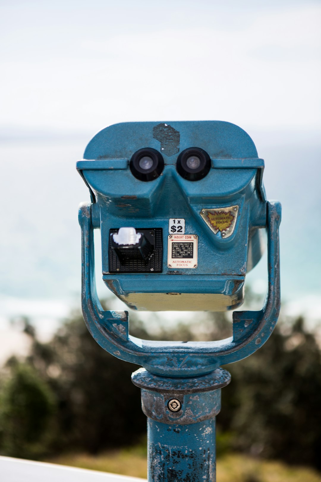 blue binoculars on green metal stand