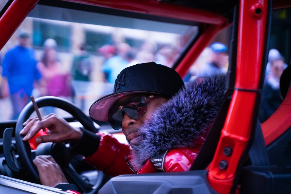 man in red jacket driving car