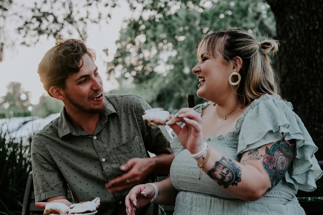 man in gray dress shirt holding girl in white dress during daytime