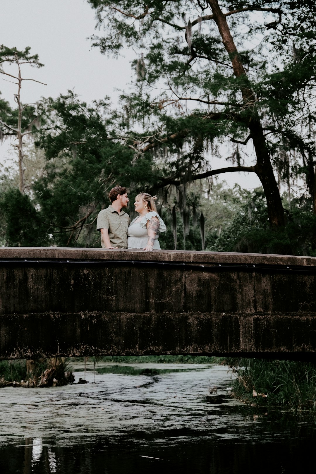 man and woman standing on bridge during daytime