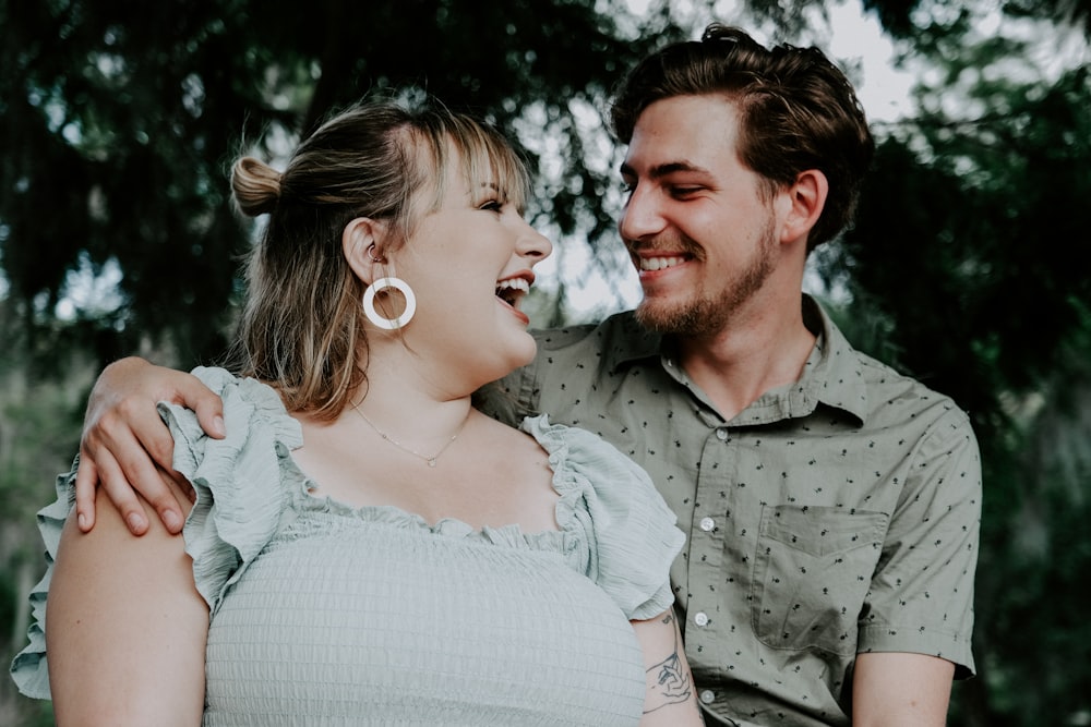 man in gray button up shirt smiling beside woman in white dress