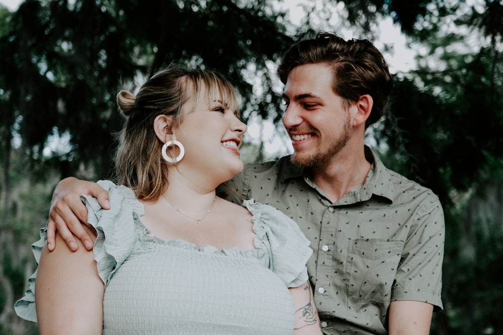 man in gray button up shirt holding woman in white dress