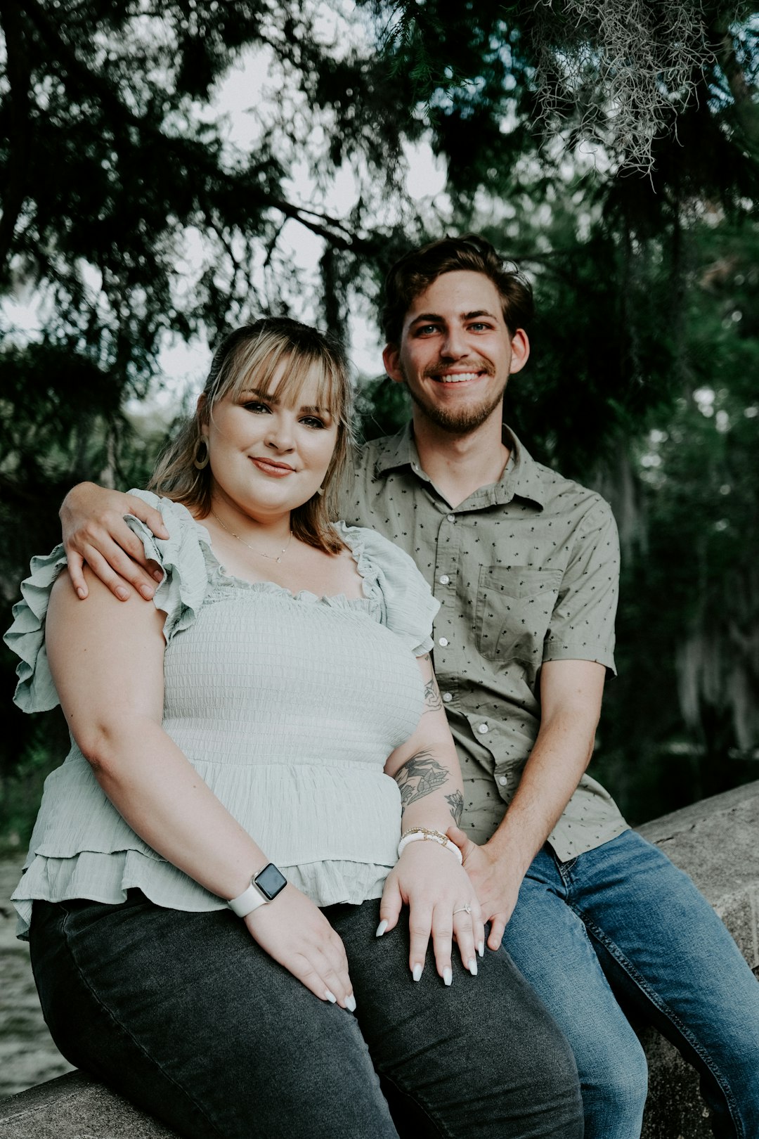 man in gray button up shirt sitting beside woman in white sleeveless dress