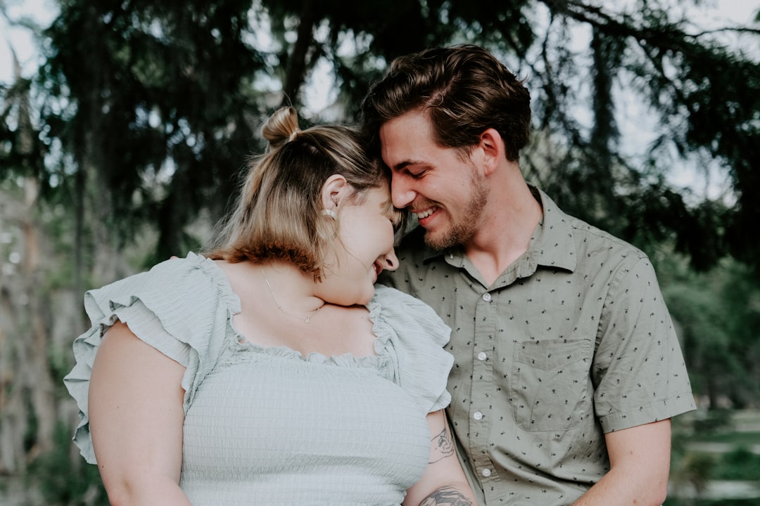 man in gray button up shirt kissing woman in white dress