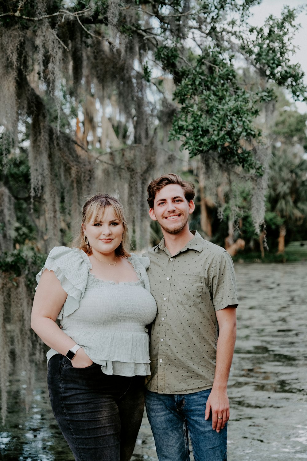 man in gray polo shirt standing beside woman in white dress