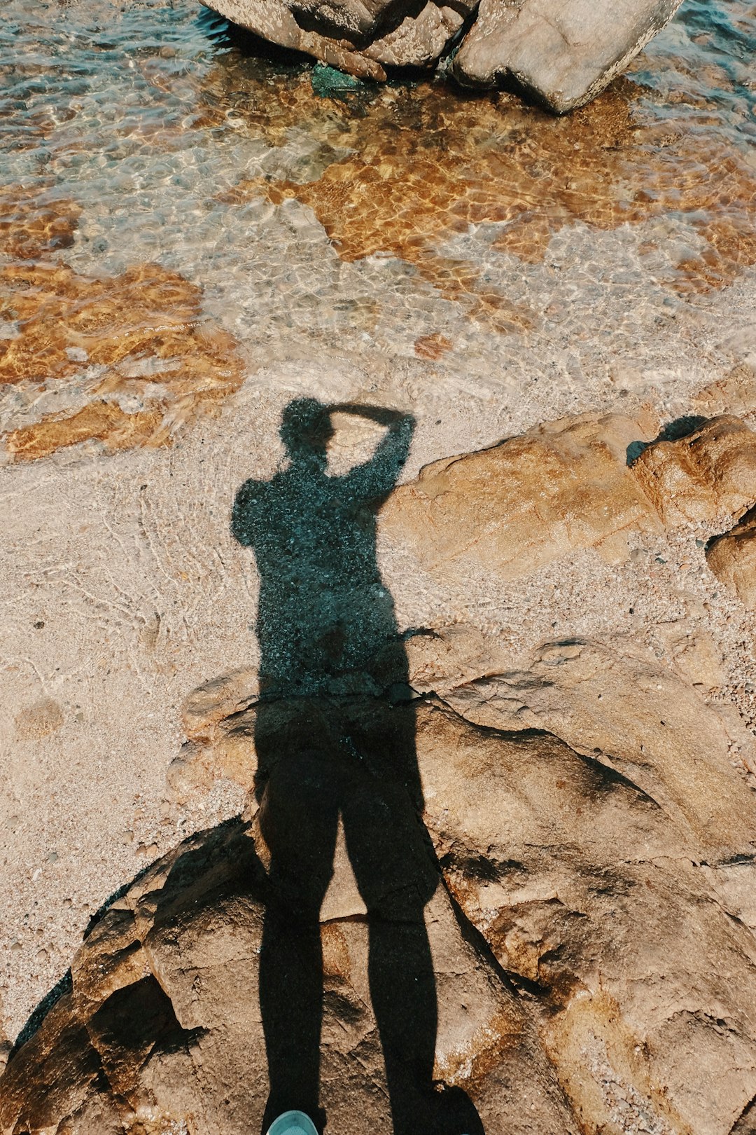 shadow of person on white sand during daytime