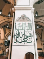 Close-up of intricate Arabic calligraphy on the walls inside the Prophet's Mosque.
