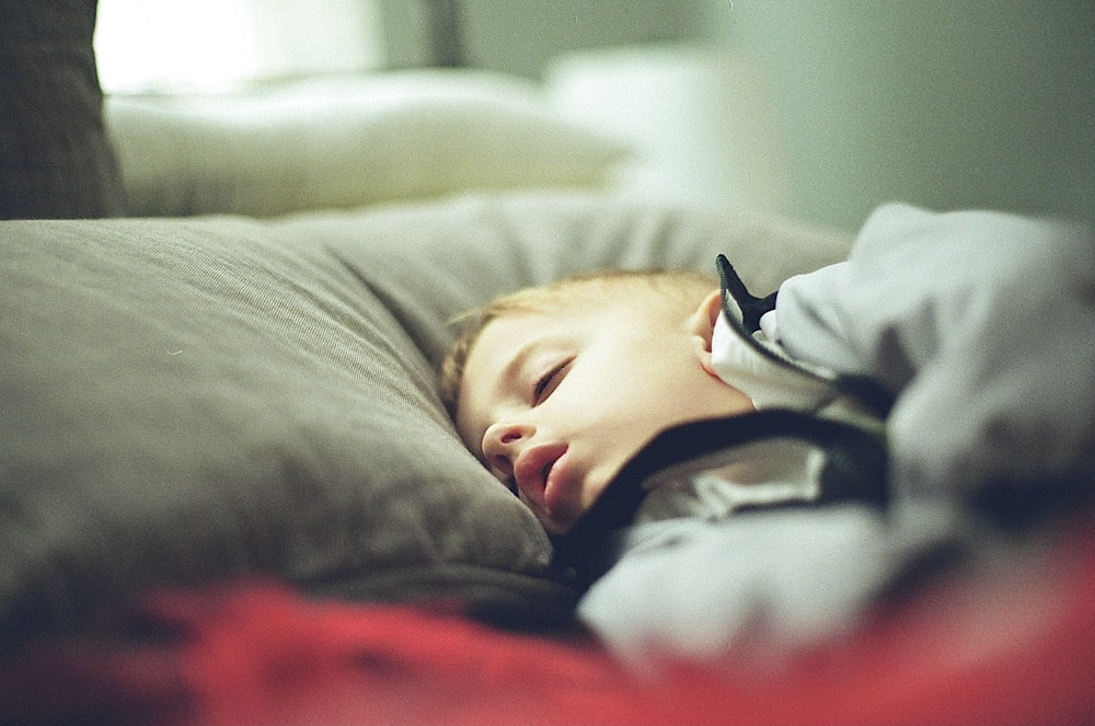 boy in white and black hoodie lying on bed
