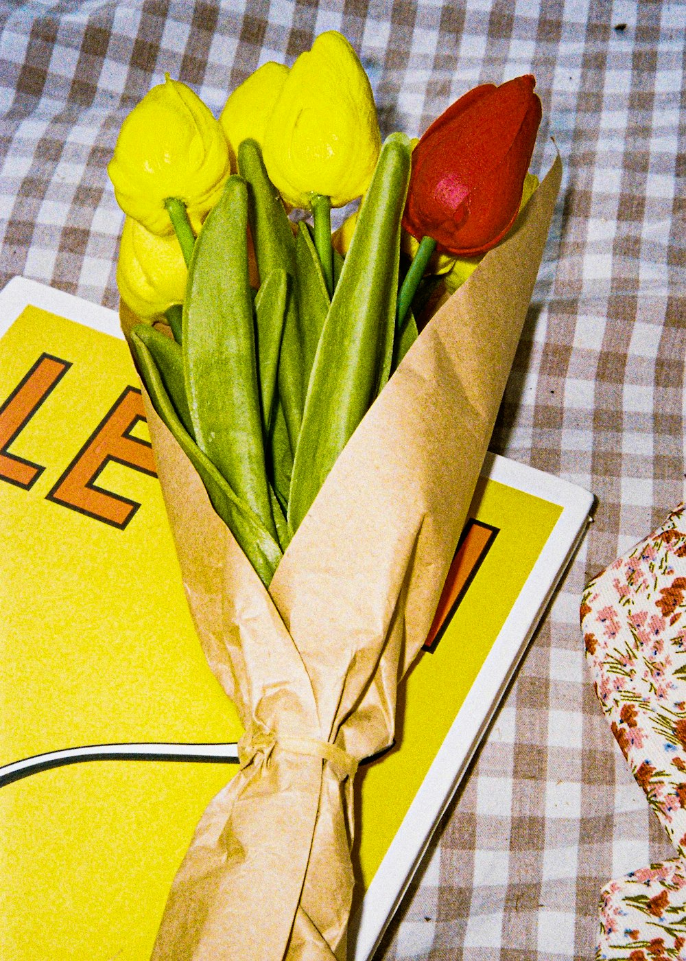 yellow tulips bouquet on white and blue floral table cloth