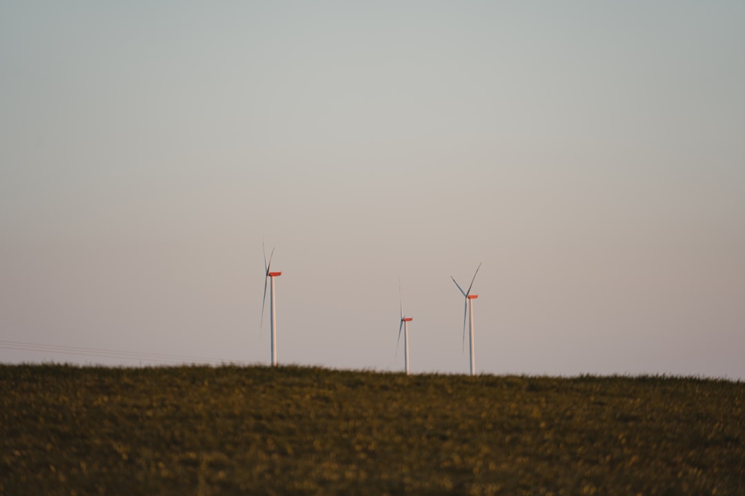 wind turbines on brown field under white sky during daytime
