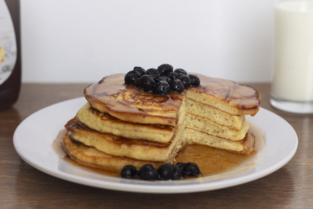 pancakes with black berries on white ceramic plate