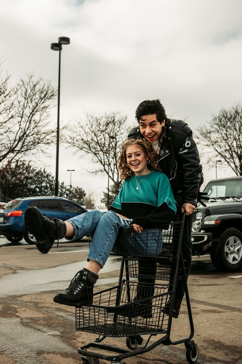 man and woman sitting on shopping cart