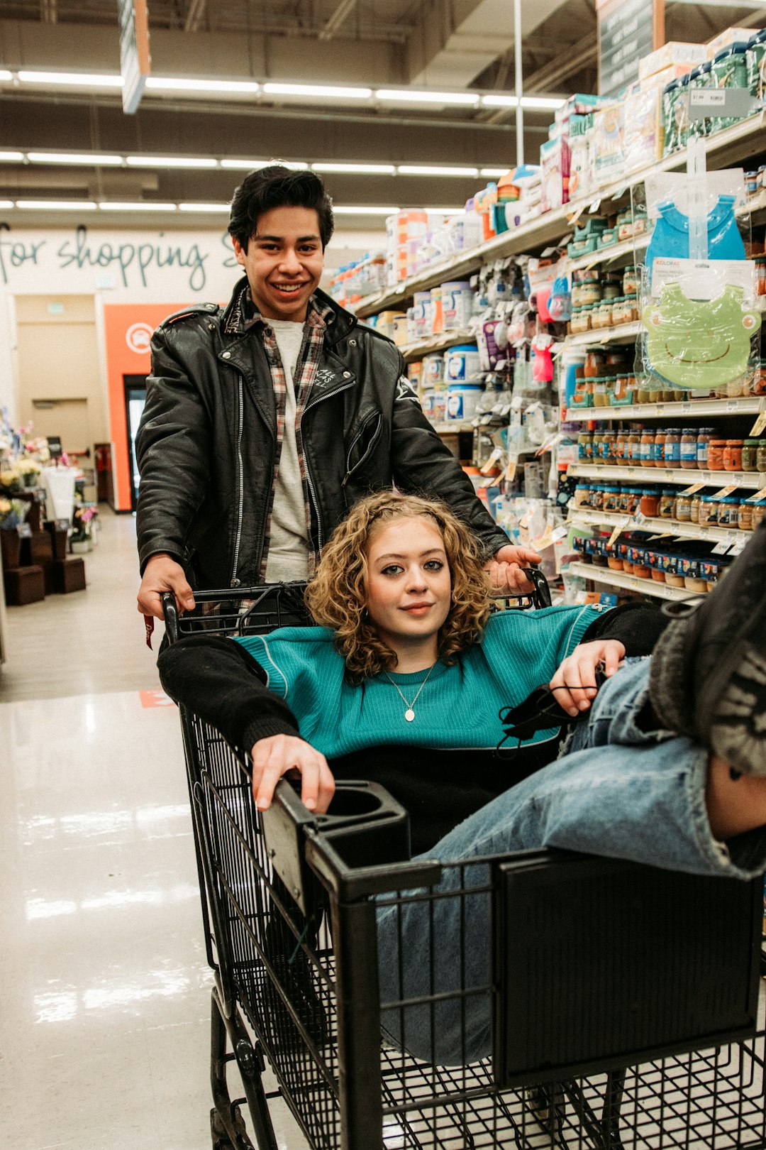 woman in black leather jacket sitting on shopping cart