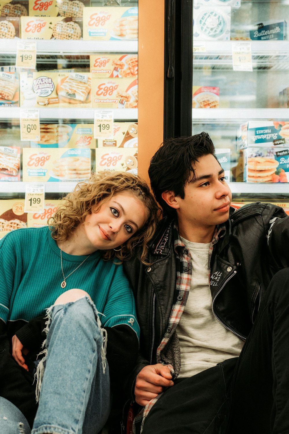 man in black leather jacket beside woman in green sweater