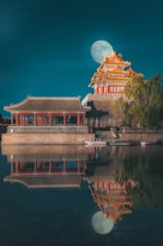 red and brown temple near body of water during daytime