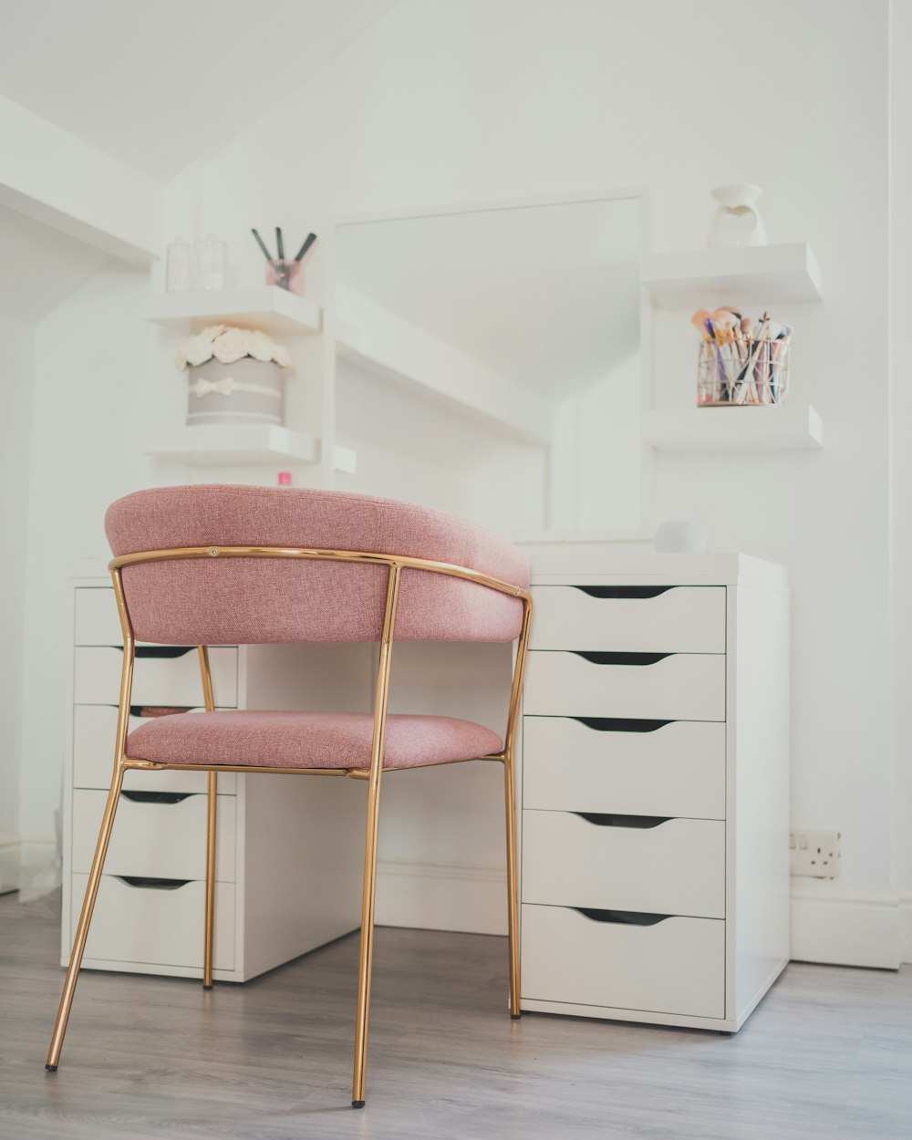 brown wooden chair beside white wooden drawer