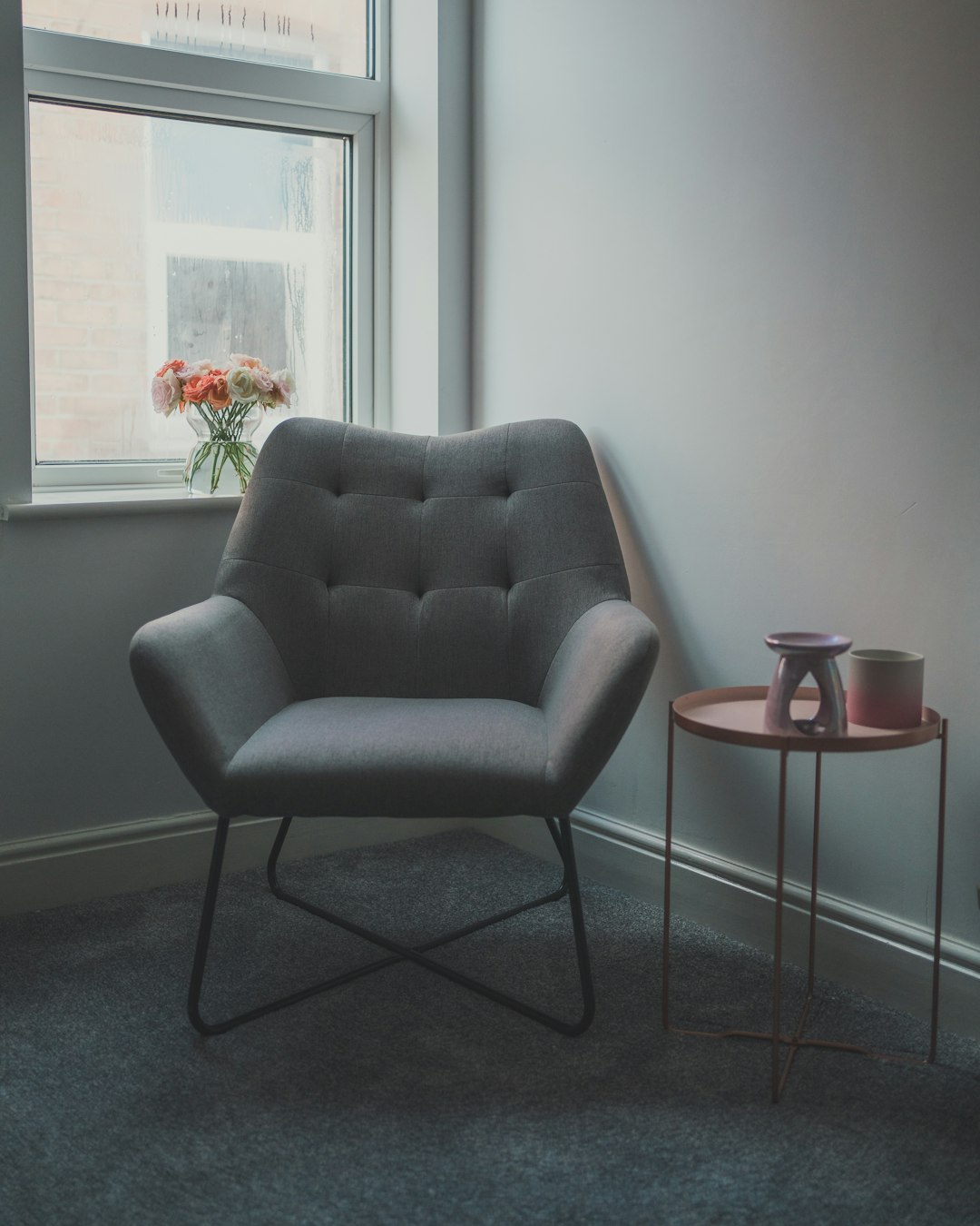  gray sofa chair beside glass window armchair