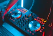 Close-up of a Numark DJ controller with illuminated pads and knobs