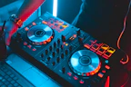 Close-up of a Numark DJ controller with illuminated pads and knobs