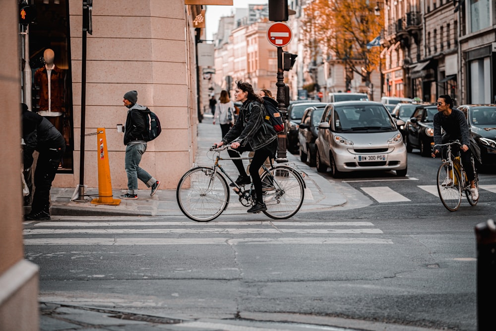 man in black jacket riding on bicycle on road during daytime