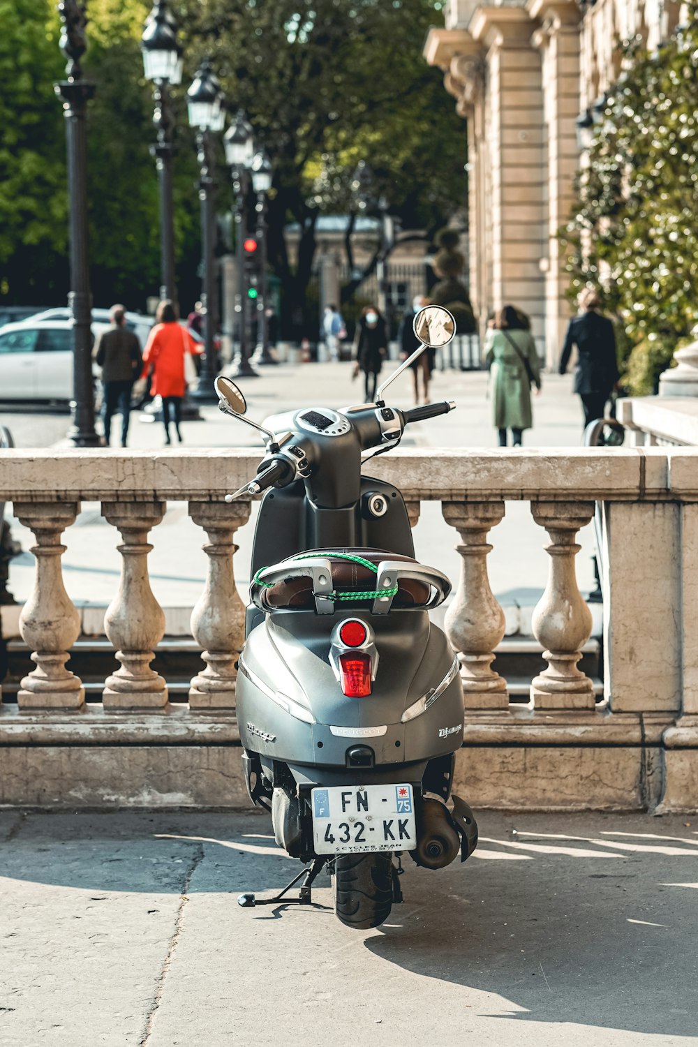 black and red motor scooter parked on sidewalk during daytime