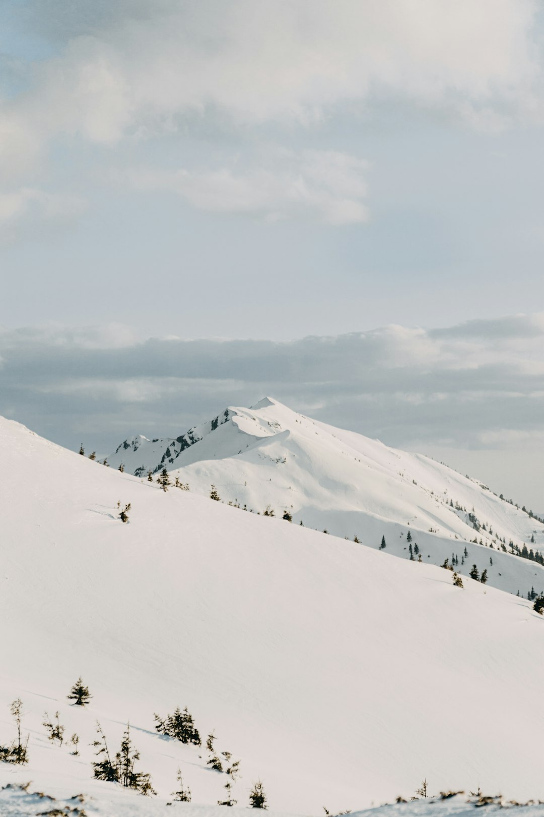 snow covered mountain under cloudy sky during daytime