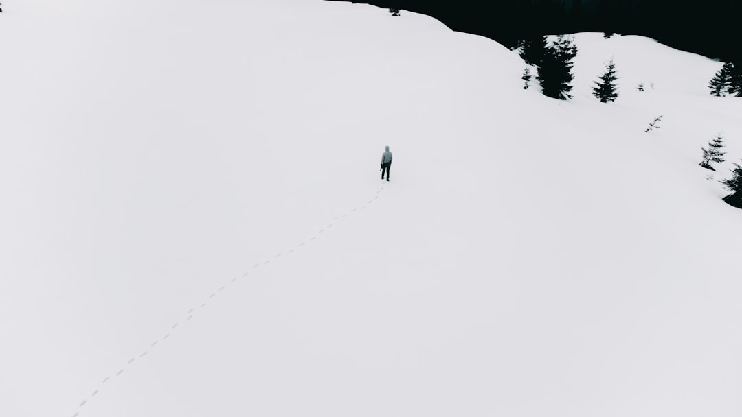 person walking on snow covered ground during daytime