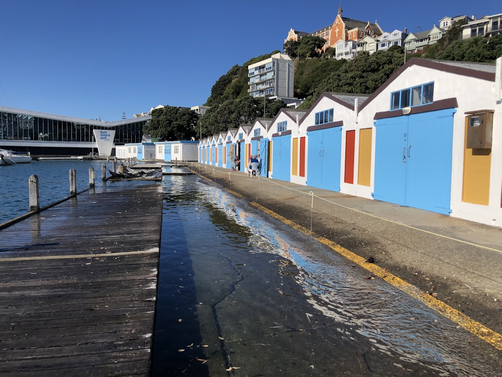 white and blue houses beside body of water during daytime