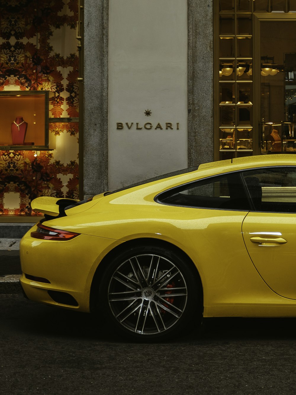 Porsche amarelo 911 estacionado perto do edifício