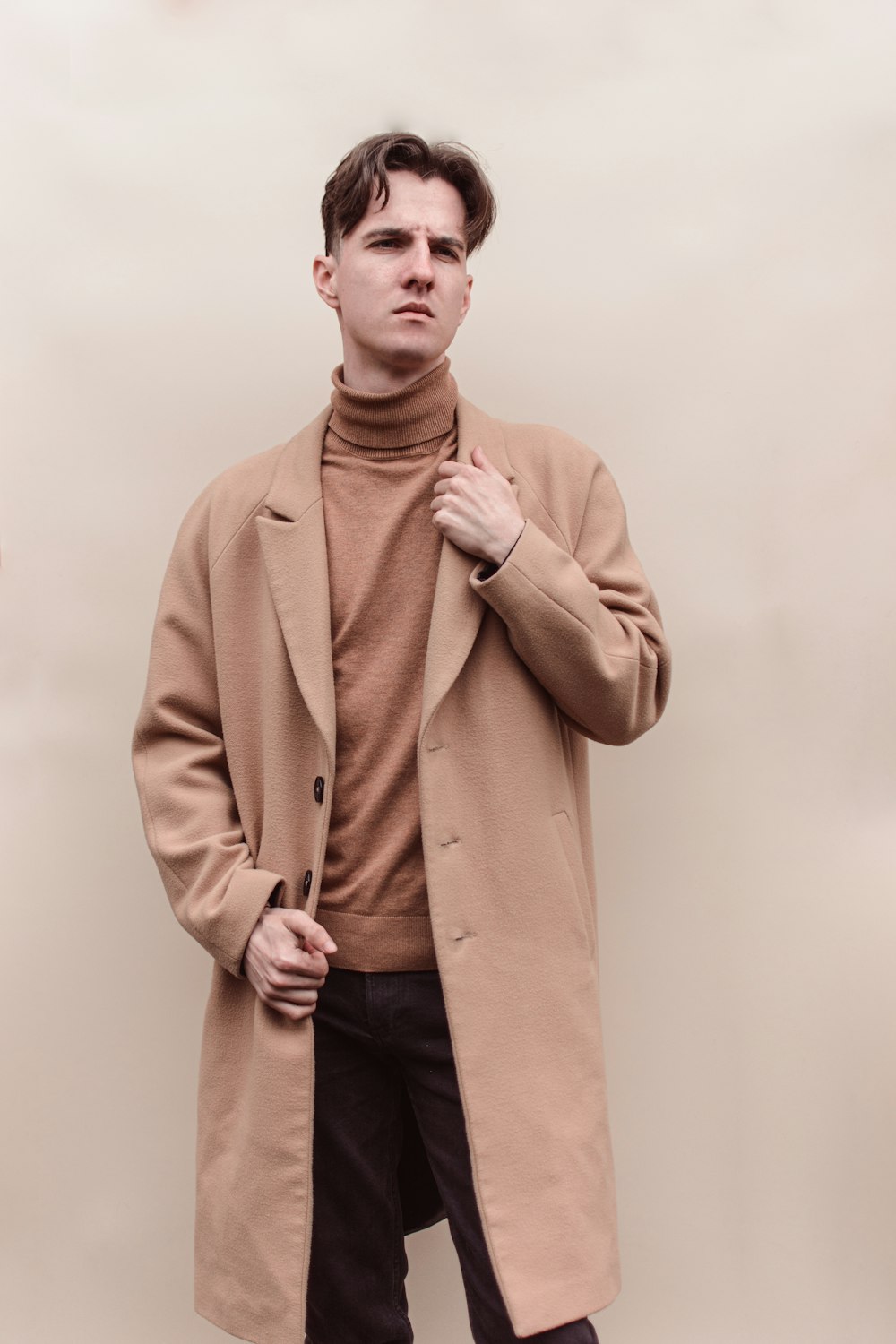 homme en manteau marron debout