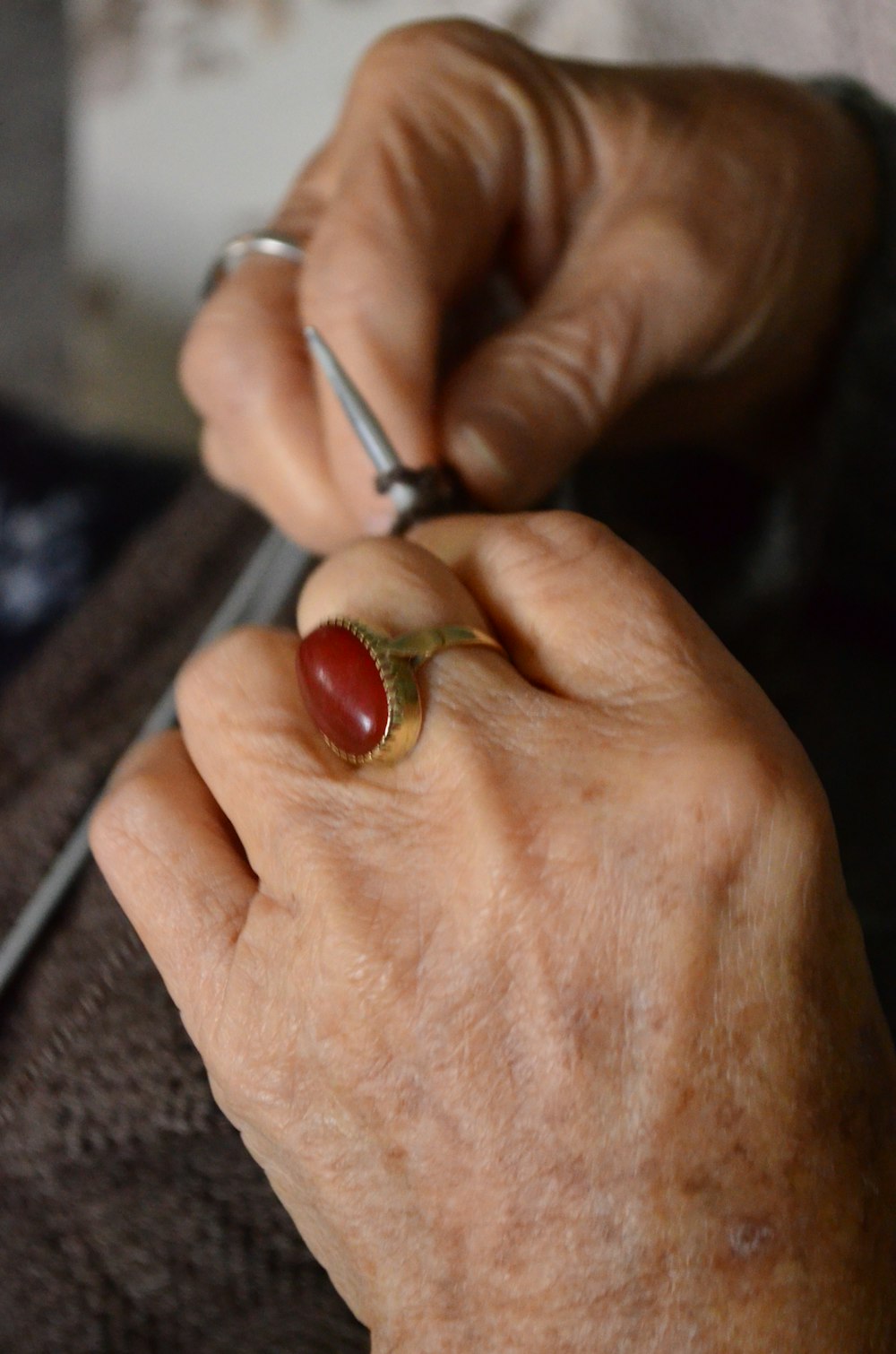 person wearing silver and red ring