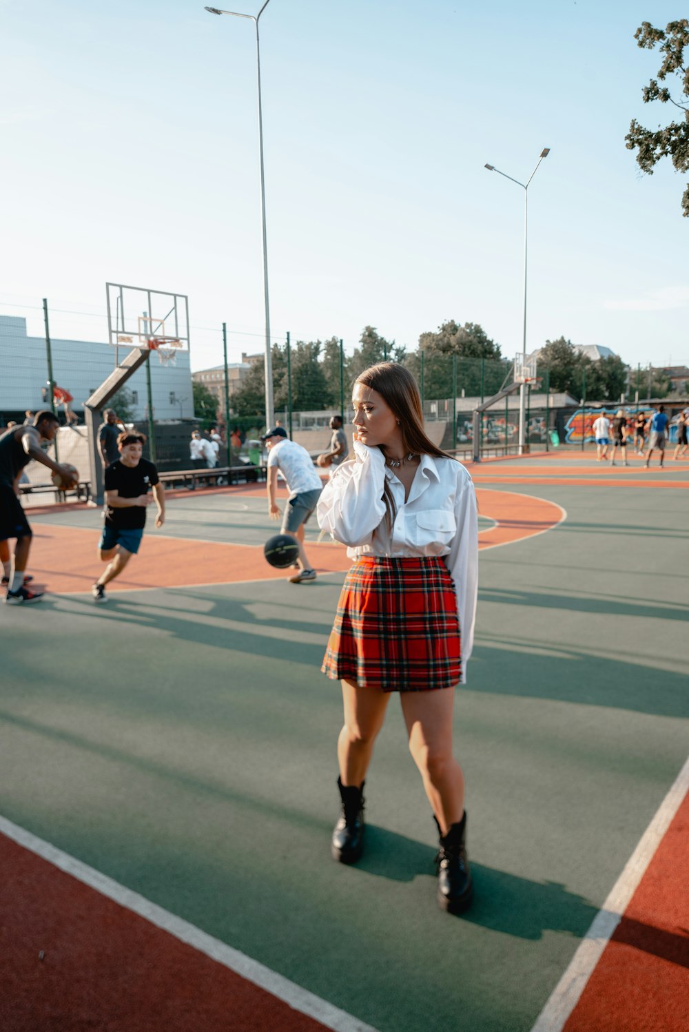 2 women in white shirt and red skirt standing on track field during daytime