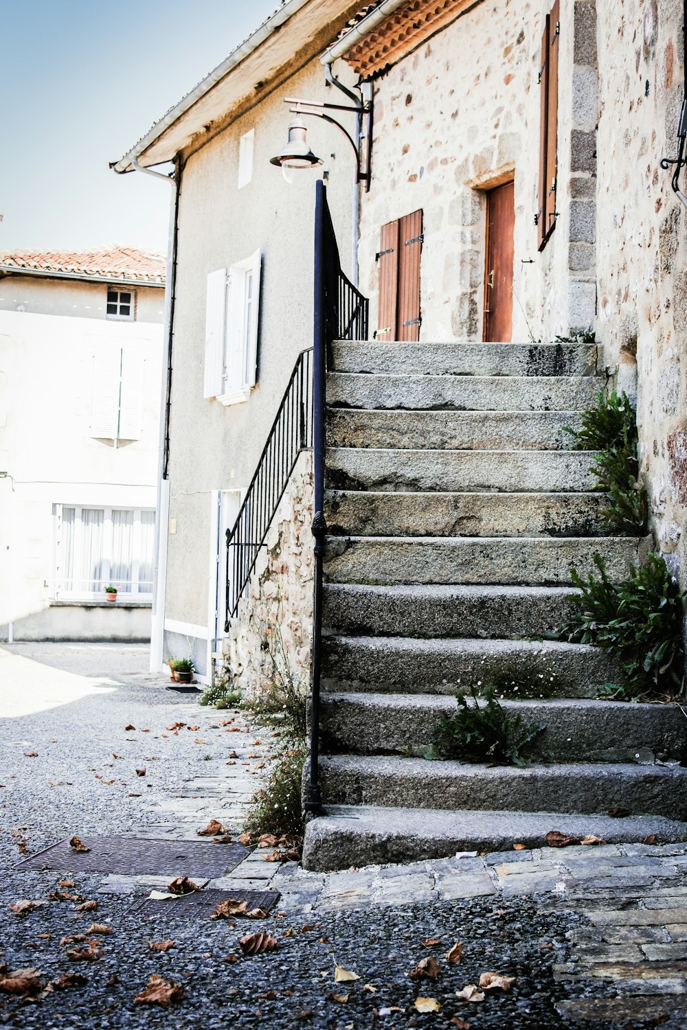 gray concrete stairs between white concrete building during daytime