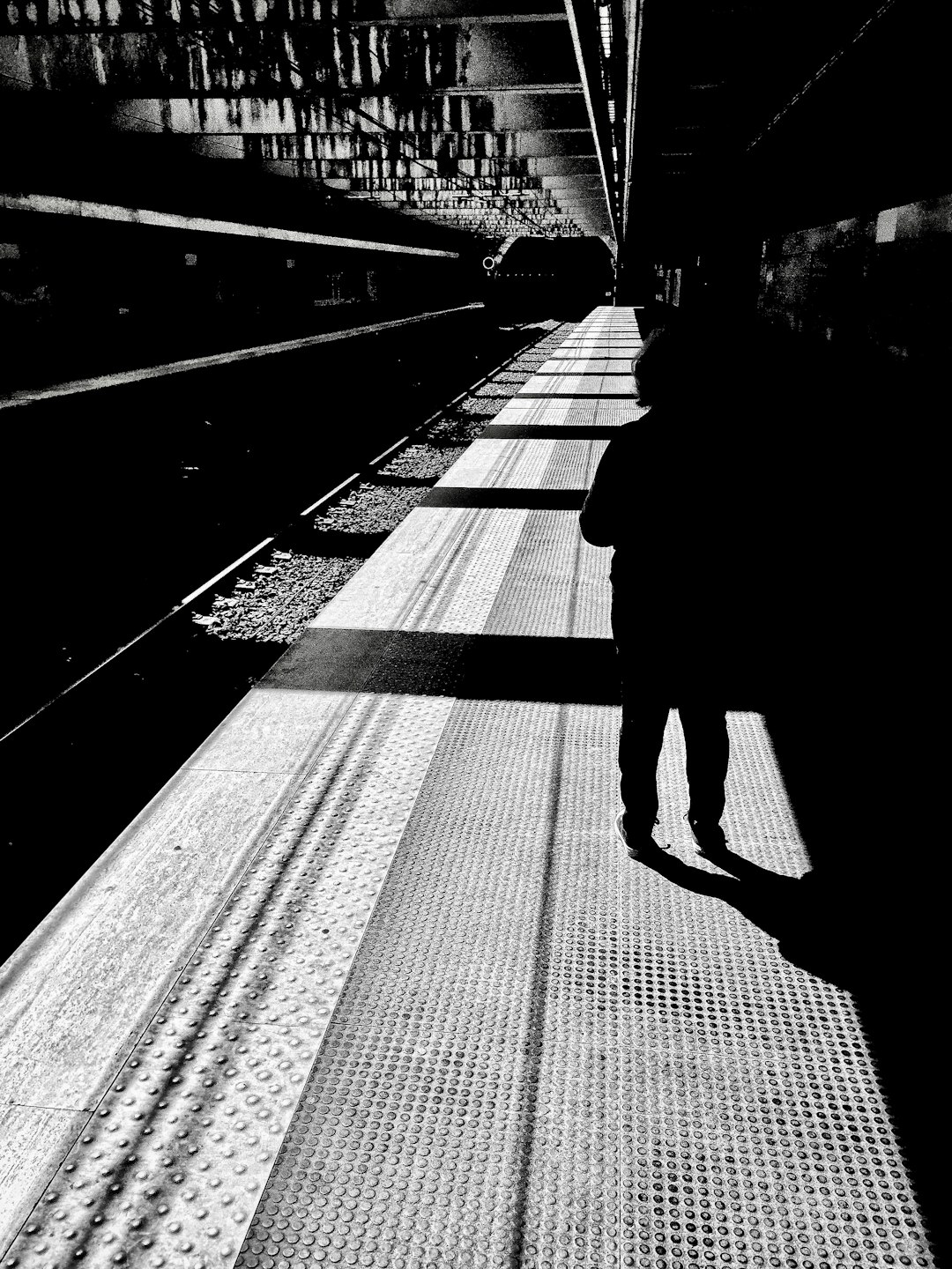 silhouette of man walking on train station