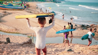 woman in white long sleeve shirt holding brown surfboard on beach during daytime