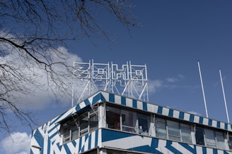white and blue concrete building near bare trees under blue sky during daytime