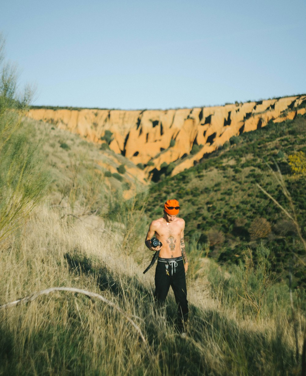 man in black pants standing on green grass field during daytime