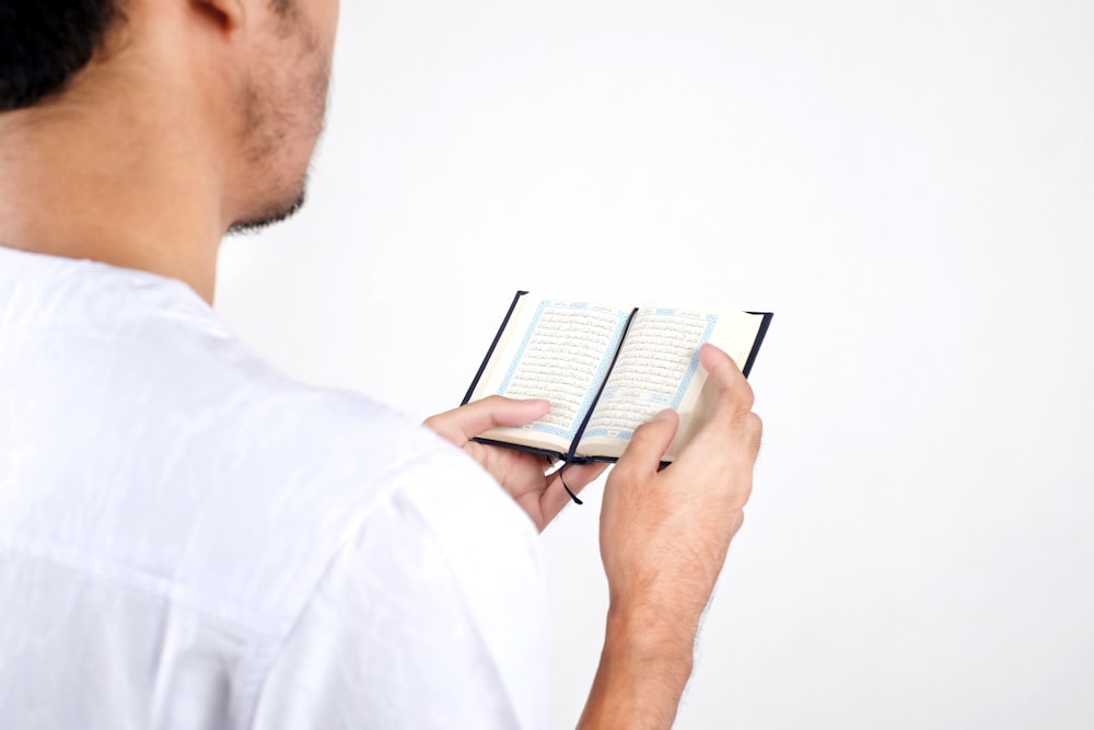 man in white dress shirt using white tablet computer