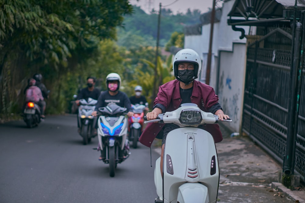 man in black helmet riding white and red motorcycle during daytime