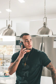 man in black crew neck t-shirt using smartphone