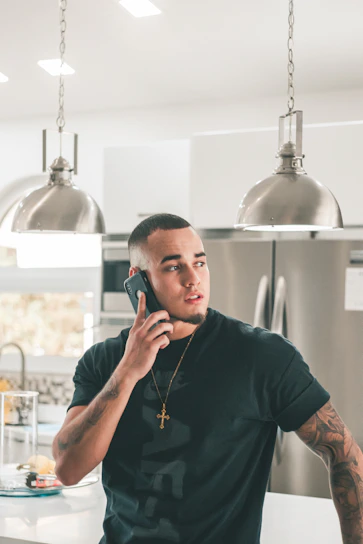 man in black crew neck t-shirt using smartphone